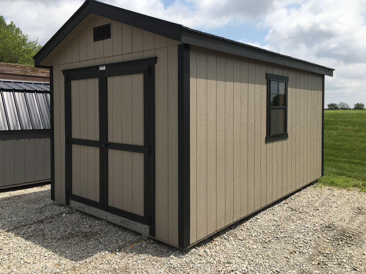 Tan storage shed with dark double barn doors